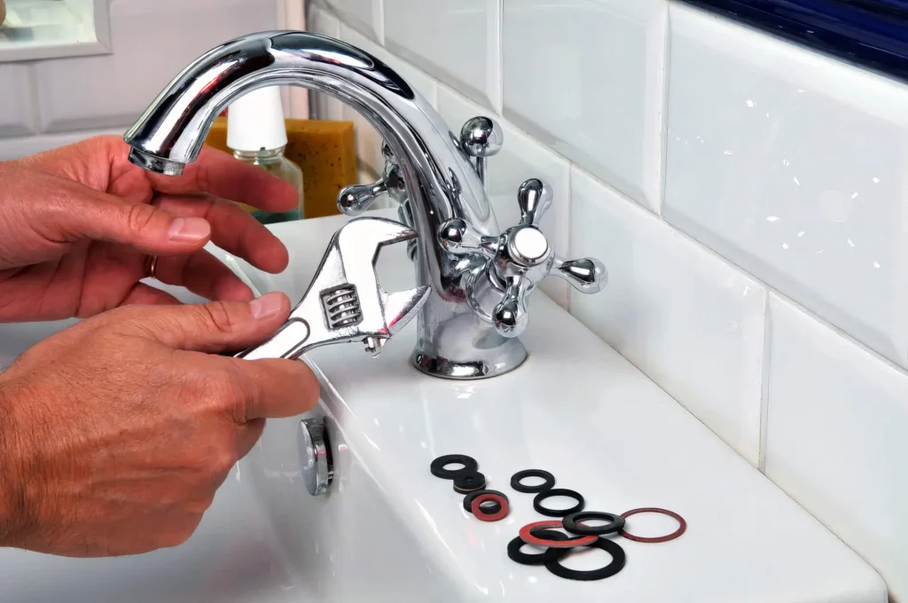 Plumber performing maintenance on a bathroom faucet in Greenacres