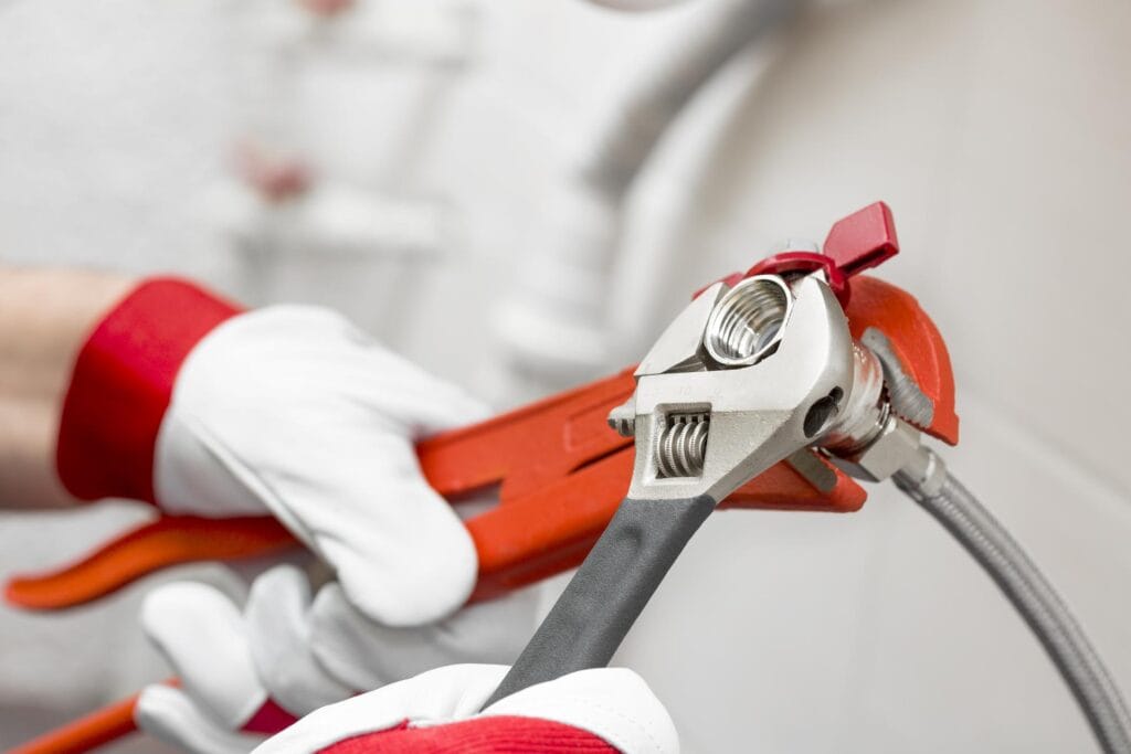 Plumber holding pipe wrenches for an emergency repair in Greenacres