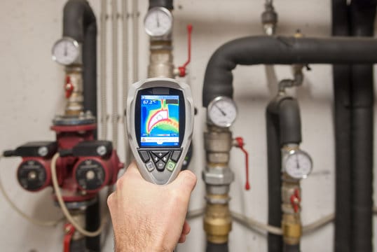 Plumber using a thermal imaging camera to inspect pipes in Greenacres