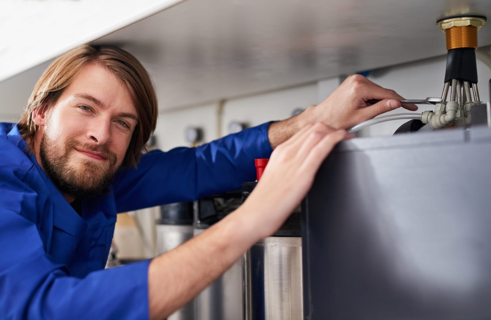 Technician servicing a residential water heater tank in Greenacres