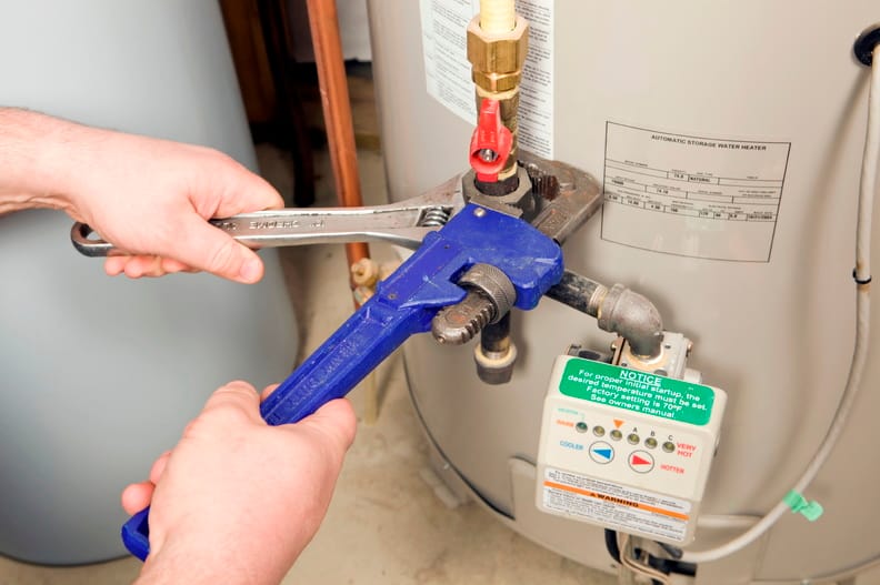 Plumber repairing a water heater valve in Greenacres